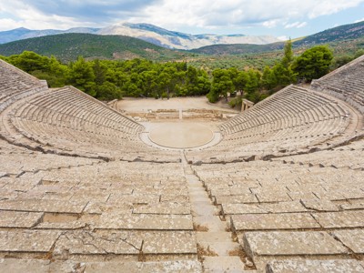 Oud amfitheater van Epidaurus in Griekenland, met uitzicht op groene heuvels en bergen.