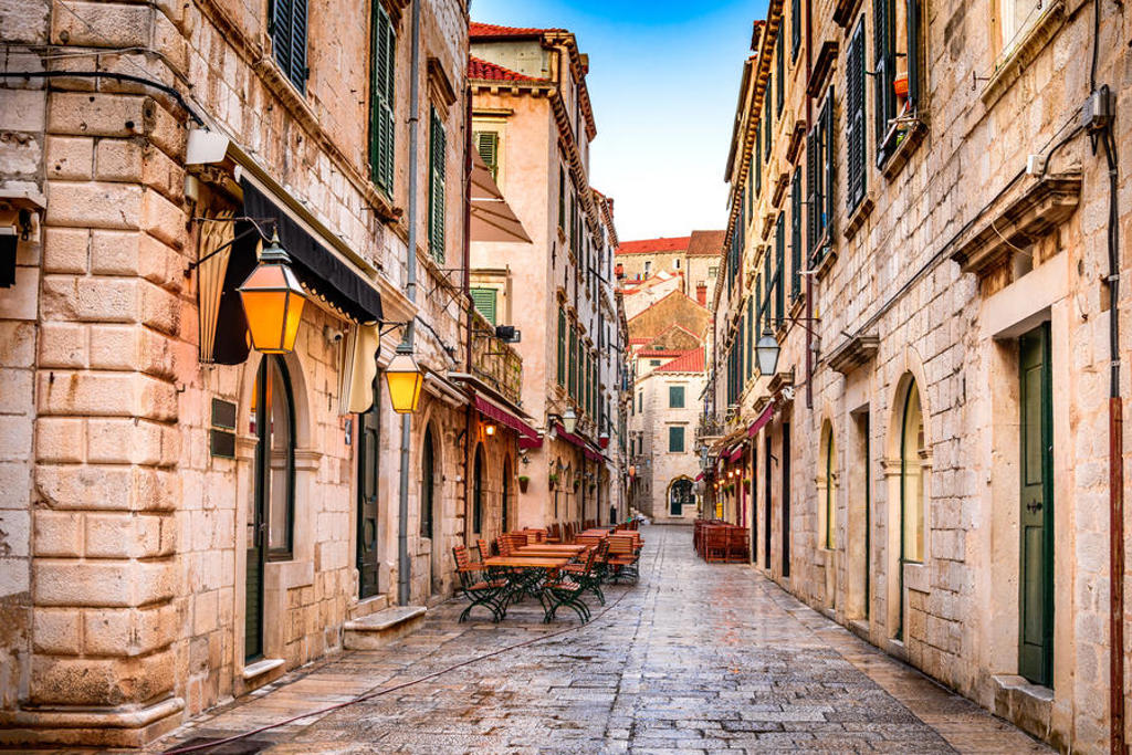 Sfeervolle straat met terrassen en lantaarns in de oude stad van Dubrovnik, Kroatië.