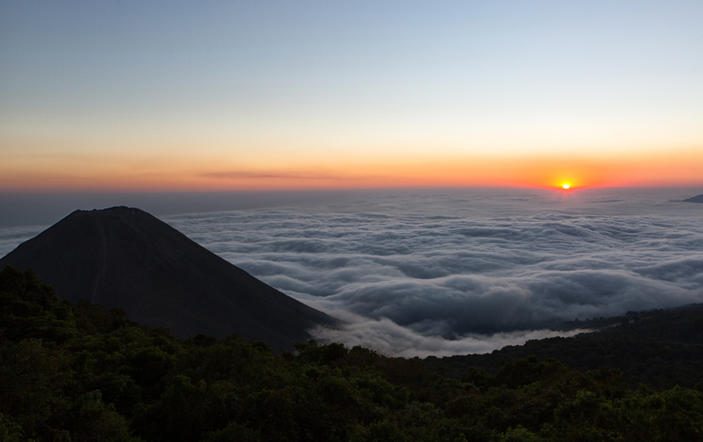 Zonsopkomst boven een vulkaan met wolkendek, tijdens 22-35ers reis Guatemala, Honduras en El Salvador.