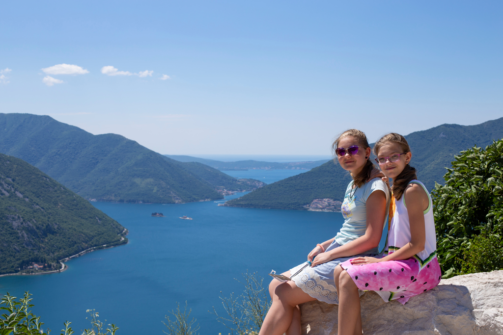 Twee meisjes genieten van het uitzicht over de Baai van Kotor in Montenegro tijdens een familiereis Kroatië en Montenegro.