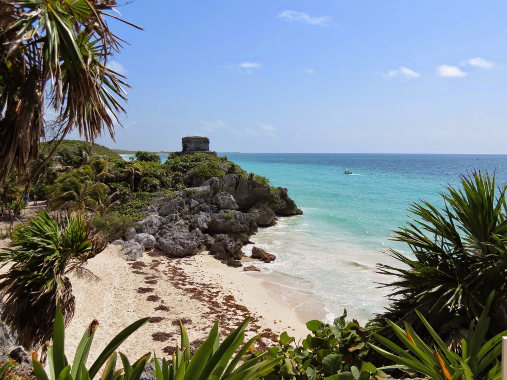 Maya-ruïnes van Tulum op de kliffen boven een wit zandstrand en turquoise zee in Mexico.