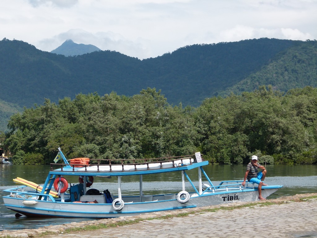 Boot aan de oever van een rivier met groene bergen op de achtergrond tijdens familiereis Argentinië en Brazilië.