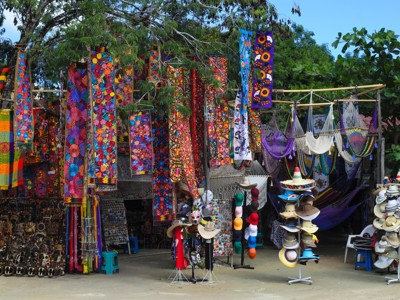 Kraampje met kleurrijke Mexicaanse textiel, hangmatten en hoeden op een lokale markt tijdens Route Mexico.