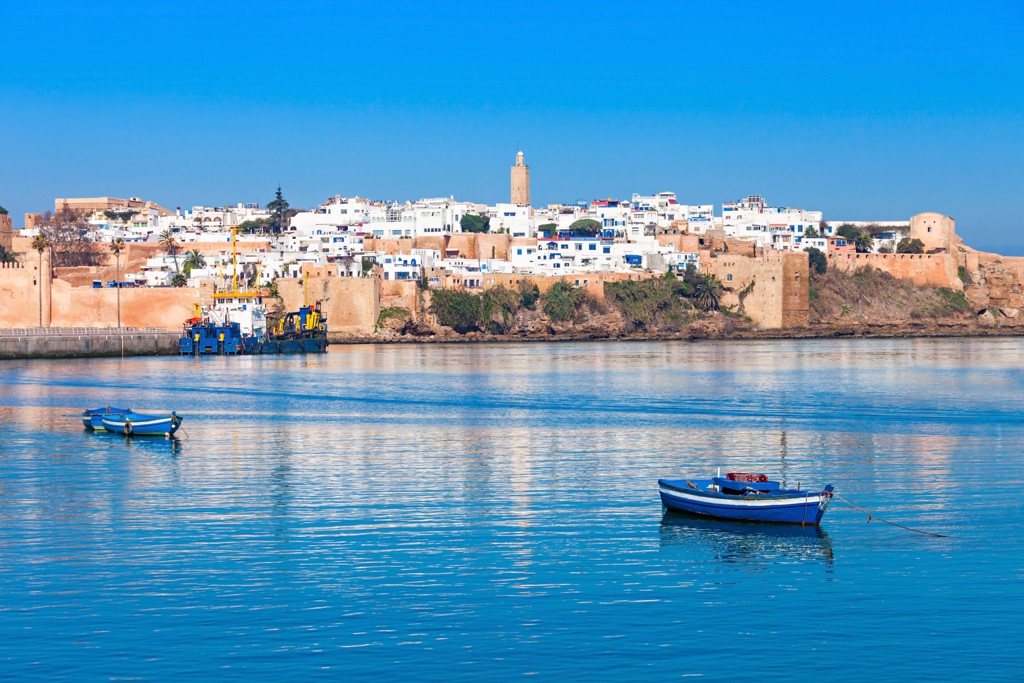 Uitzicht op de kust van Rabat met vestingmuren en bootjes op het water tijdens rondreis Andalusië.