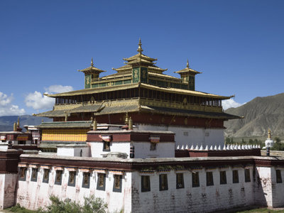 Tibetaans boeddhistisch klooster met goudkleurige daken in berglandschap langs de route Tibet en Nepal.