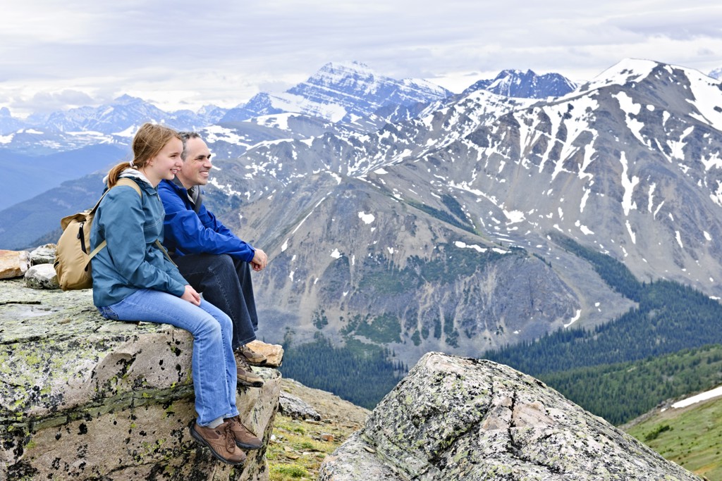 Gezin geniet van uitzicht op besneeuwde bergtoppen in de Canadese Rockies tijdens familiereis Canada West.