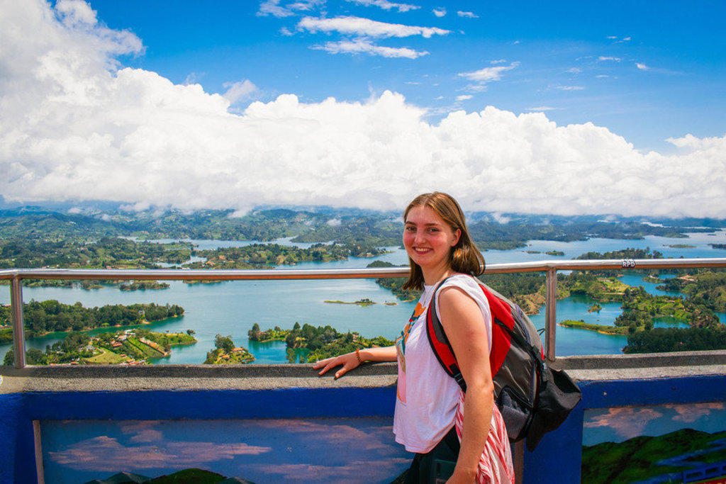 Reiziger op uitzichtpunt met panorama over het Guatapé-reservoir bij Medellín, tijdens 22-35ers reis Colombia.