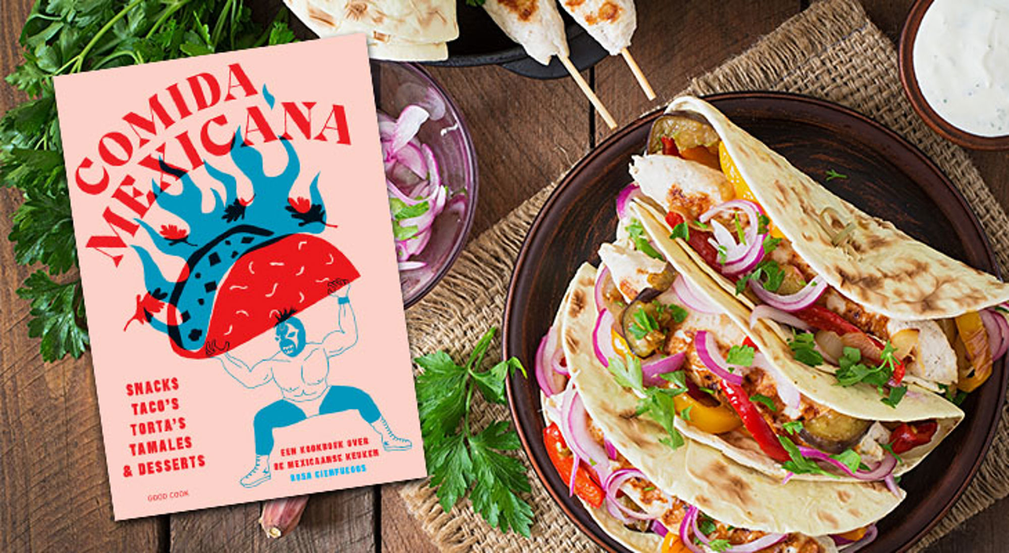 Kookboek “Comida Mexicana” naast een bord met gevulde taco’s, rode ui en koriander.