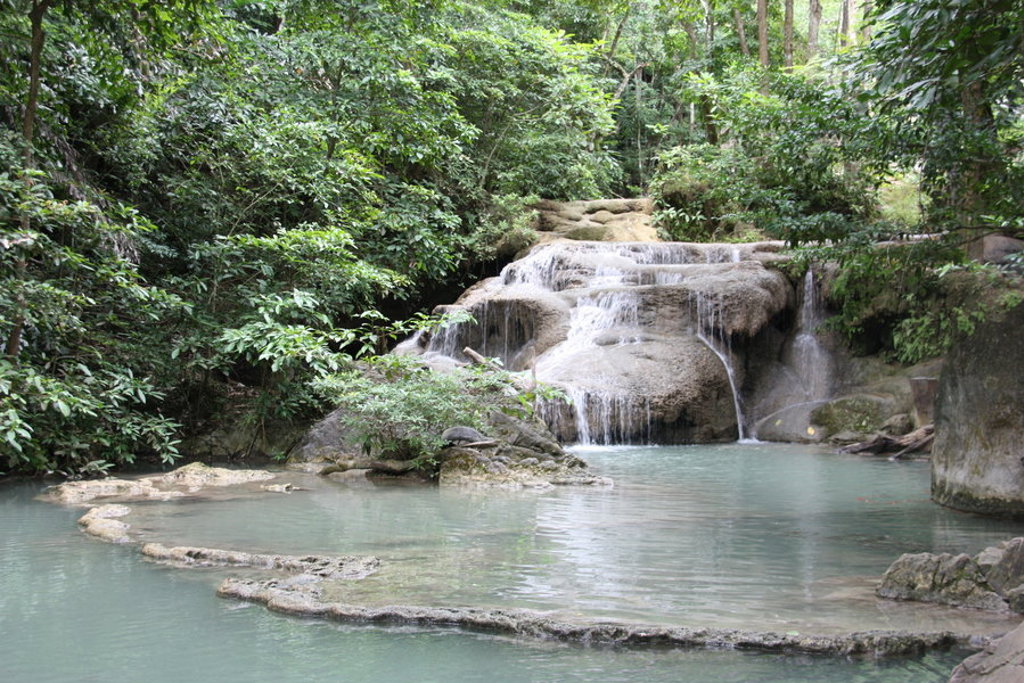Waterval met turquoise poel in het groene regenwoud van Thailand tijdens familiereis Noord en Zuid.