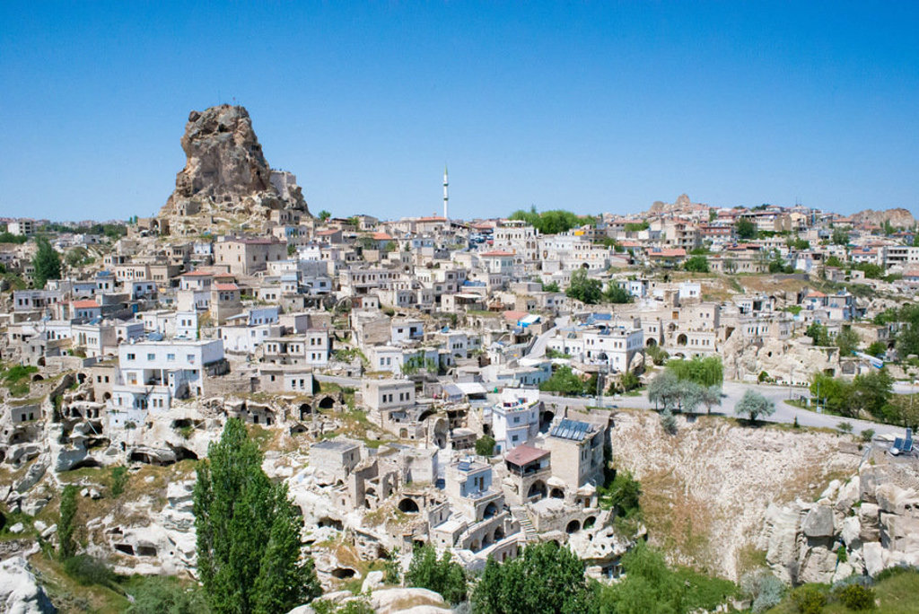 Uitzicht op het rotsstadje Uçhisar in Cappadocië, Turkije, met huizen in tufsteen en een rotsburcht.