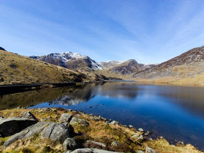 Bergmeer in het Lake District met besneeuwde toppen en spiegeling in het water.