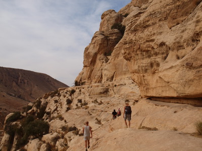 Wandelaars op rotsachtig pad langs zandstenen kliffen in Jordanië tijdens Route Jordanië.