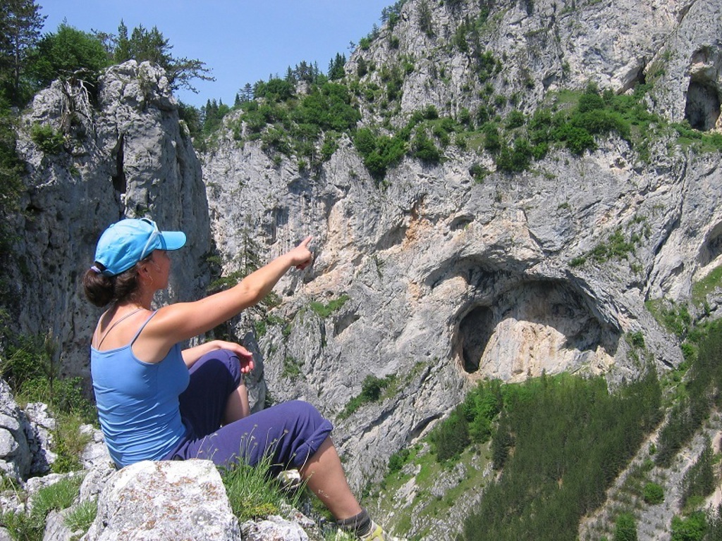 Wandelaar wijst naar rotswand in de Bulgaarse Balkan tijdens wandelvakantie Bulgarije.