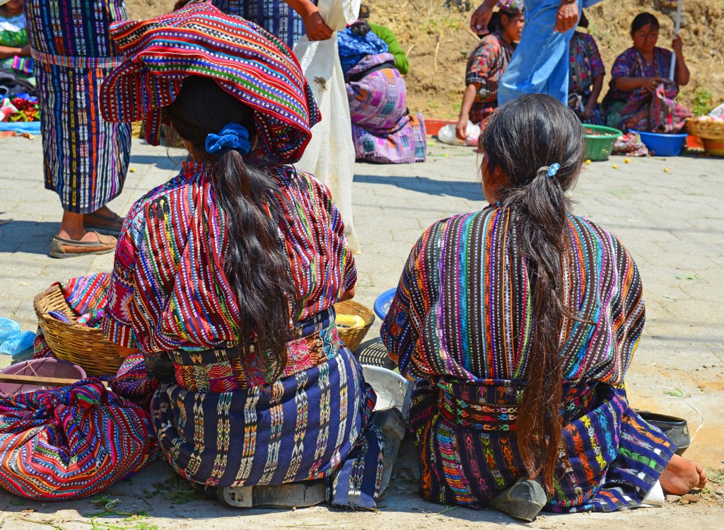 Vrouwen in kleurrijke traditionele kleding op een markt in Guatemala tijdens een familiereis Guatemala en Belize.