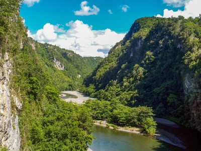 Groene vallei met rivier tussen steile rotswanden in Cuba, tijdens Route Cuba  (24 dagen).