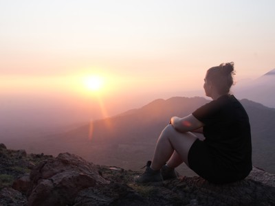 Reiziger kijkt bij zonsopgang uit over berglandschap tijdens de route Costa Rica en Nicaragua.