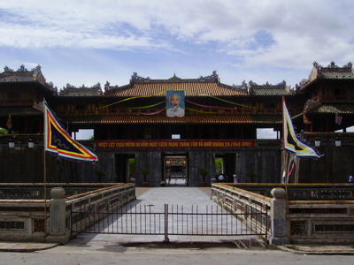 Keizerlijke Citadel in Hué met poort, brug en vlaggen, onderdeel van de Route Vietnam.