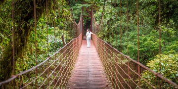 Reiziger loopt over hangbrug door het regenwoud in Costa Rica.