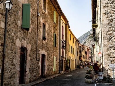 Smalle straat met stenen huizen en gekleurde luiken in een bergdorp langs de Route Canigou in de Pyreneeën.