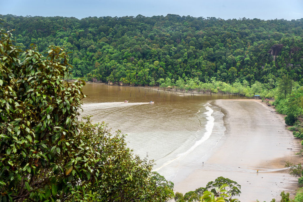 Groene jungle en brede riviermonding met zandstrand in Maleisisch Borneo.