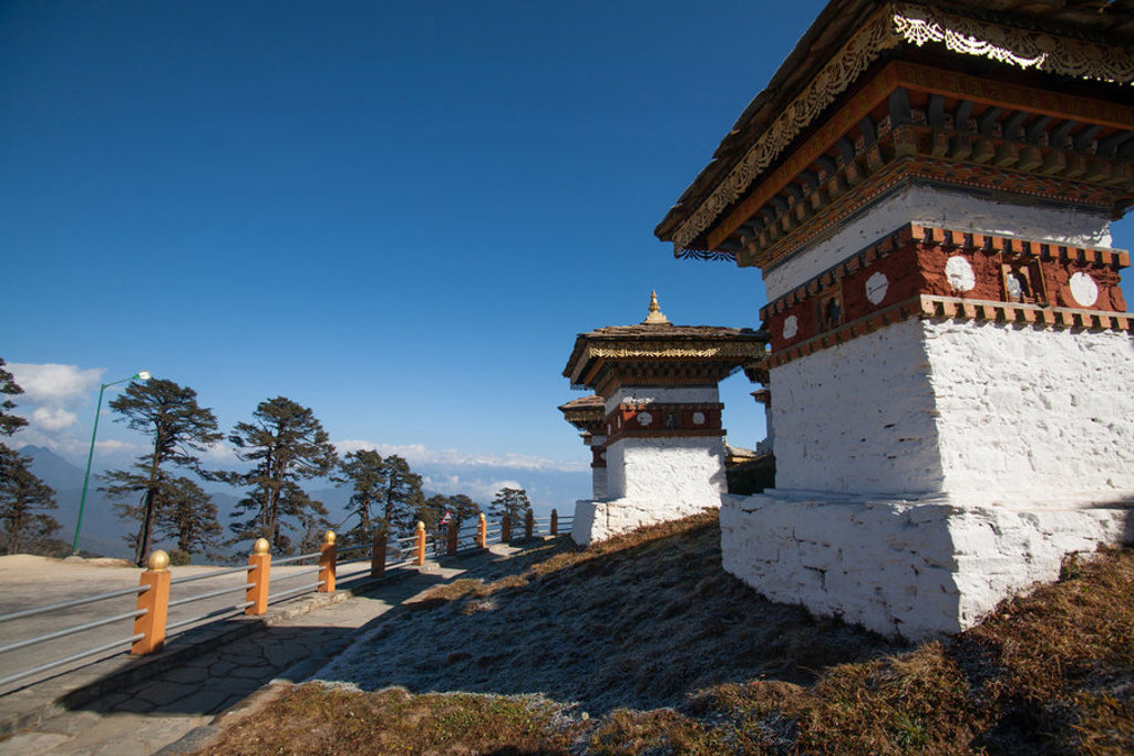 Bhutaanse chortens langs een bergweg met uitzicht op de Himalaya tijdens de groepsrondreis Sikkim en Bhutan.