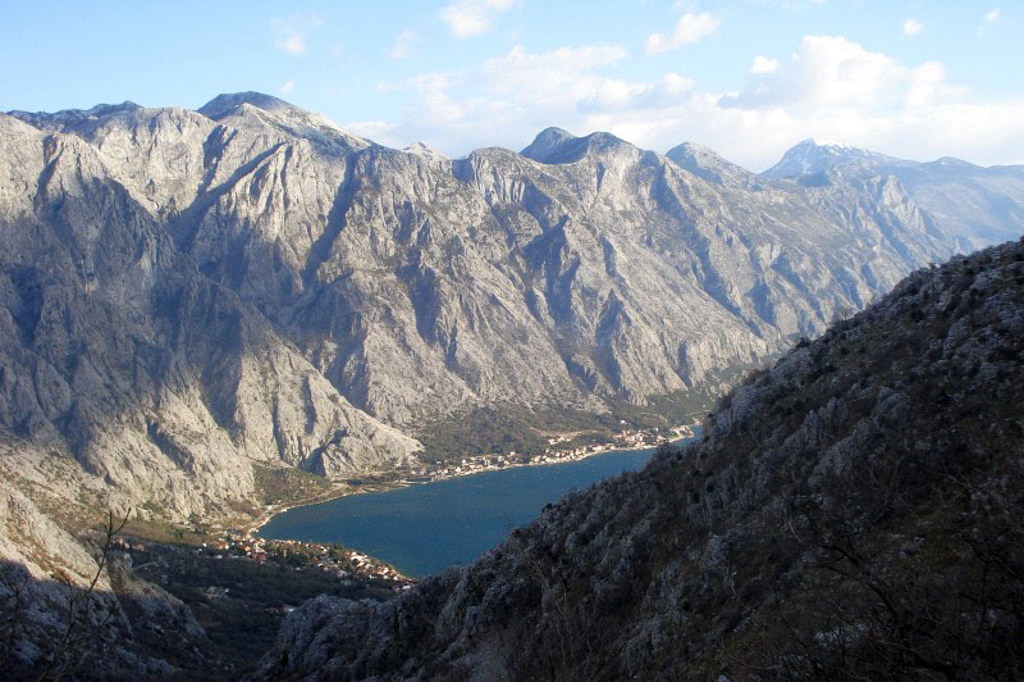 Uitzicht op de Baai van Kotor met steile bergen tijdens een wandelvakantie in Montenegro.