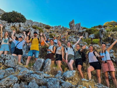 Groep wandelaars poseert op rotsachtig bergpad tijdens groepsrondreis in Andalusië, Spanje.