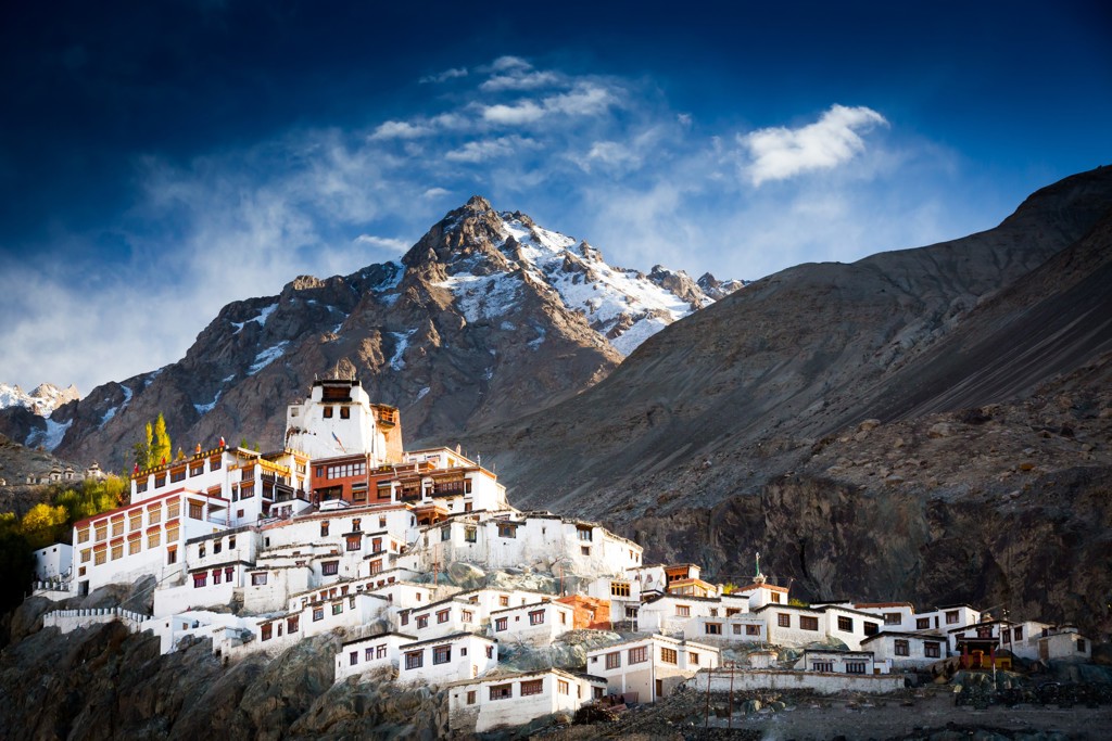 Boeddhistisch klooster in Ladakh, India, met besneeuwde bergtoppen op de achtergrond.