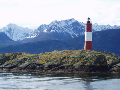 Vuurtoren bij Ushuaia met besneeuwde bergtoppen op de achtergrond, tijdens de route Patagonië.