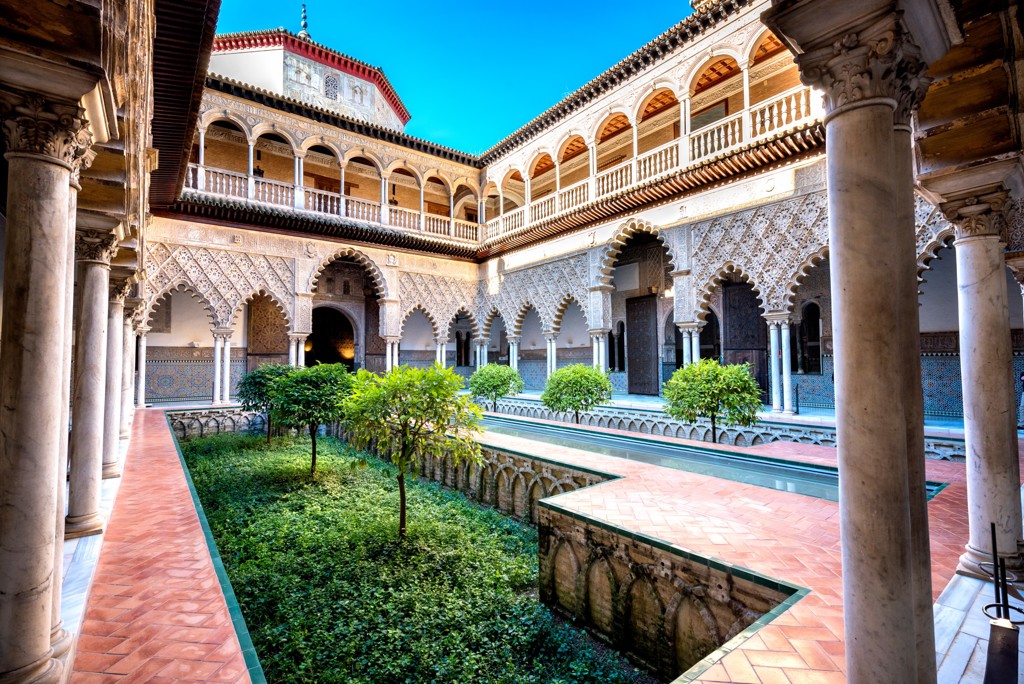 Binnenplaats van het Real Alcázar in Sevilla met Moorse bogen, zuilengalerijen en tuin tijdens rondreis Andalusië.