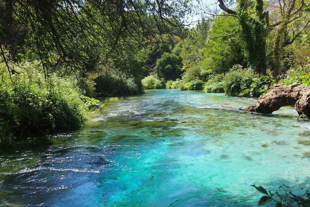 Helderblauwe rivier tussen groen boslandschap tijdens familiereis Zuid-Oost Europa.
