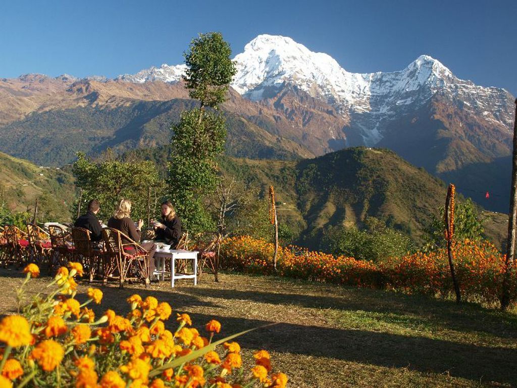 Reizigers genieten van een terras met uitzicht op de Himalaya tijdens een 22-35ers reis Nepal.