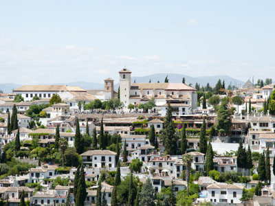 Uitzicht op de wijk Albaicín in Granada met witte huizen, cipressen en kerktorens tijdens de groepsrondreis Andalusië.