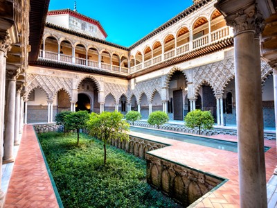 Binnenplaats van het Real Alcázar in Sevilla met Moorse bogen, zuilengalerijen en tuin.