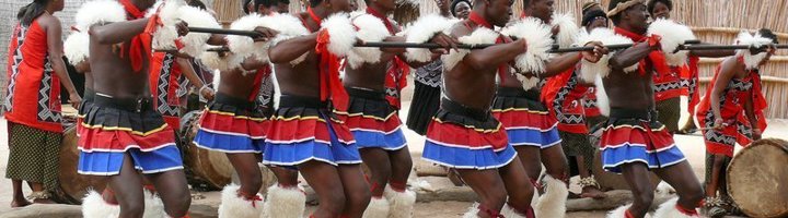 Traditionele dansers in kleurrijke kledij tijdens een culturele ceremonie in eSwatini (Swaziland).
