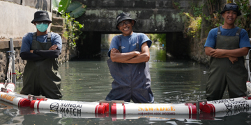 Sungai Watch-team plaatst een drijvende barrière in een kanaal om plastic afval tegen te houden.