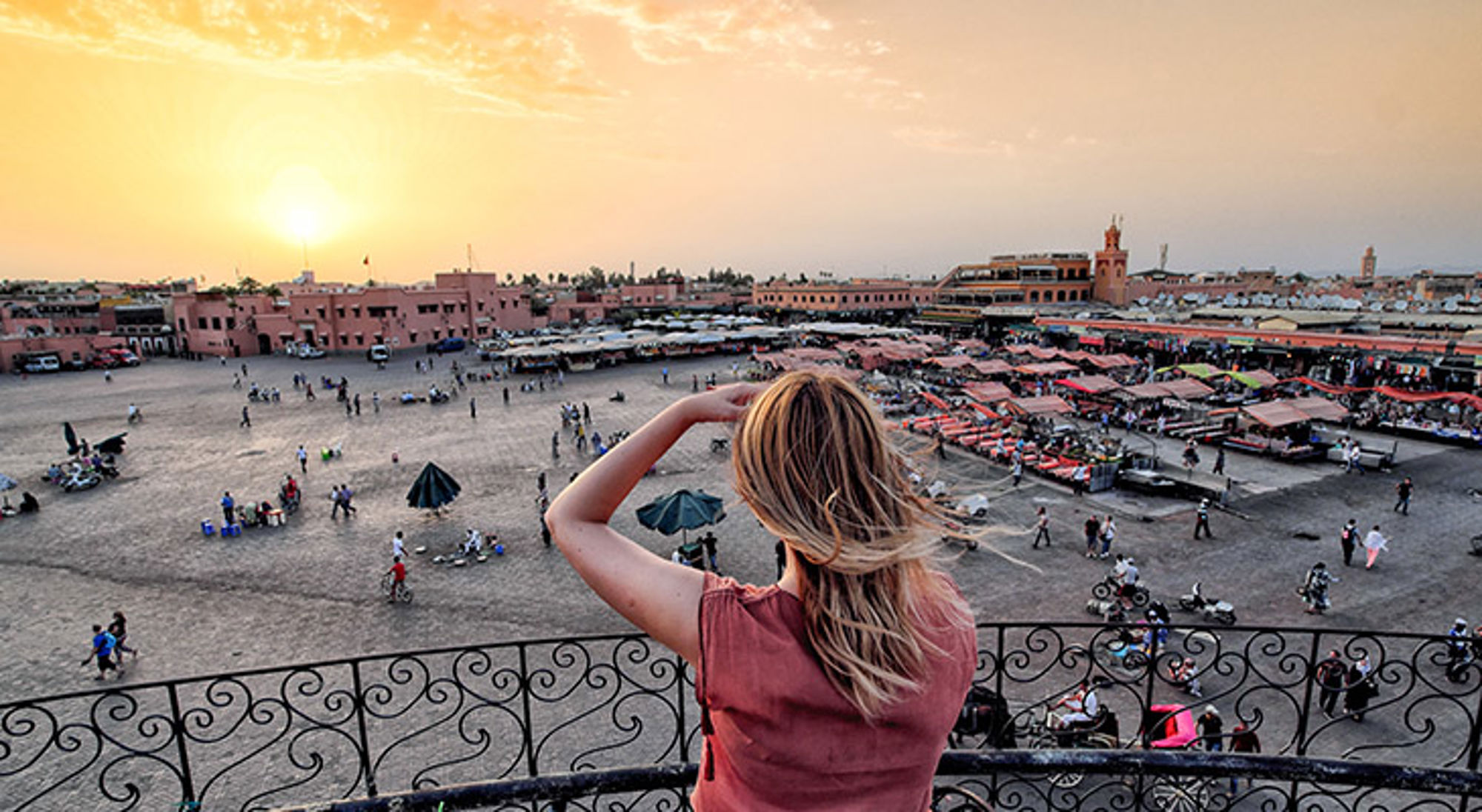 Djemaa el Fna Marrakech Uitzicht op het Jemaa el-Fna-plein in Marrakech bij zonsondergang, met marktkramen en bezoekers.