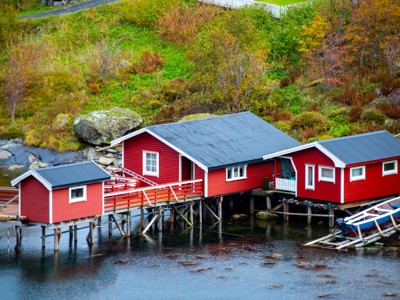 Rode rorbuer vissershuisjes op palen aan het water op de Lofoten in Noorwegen.