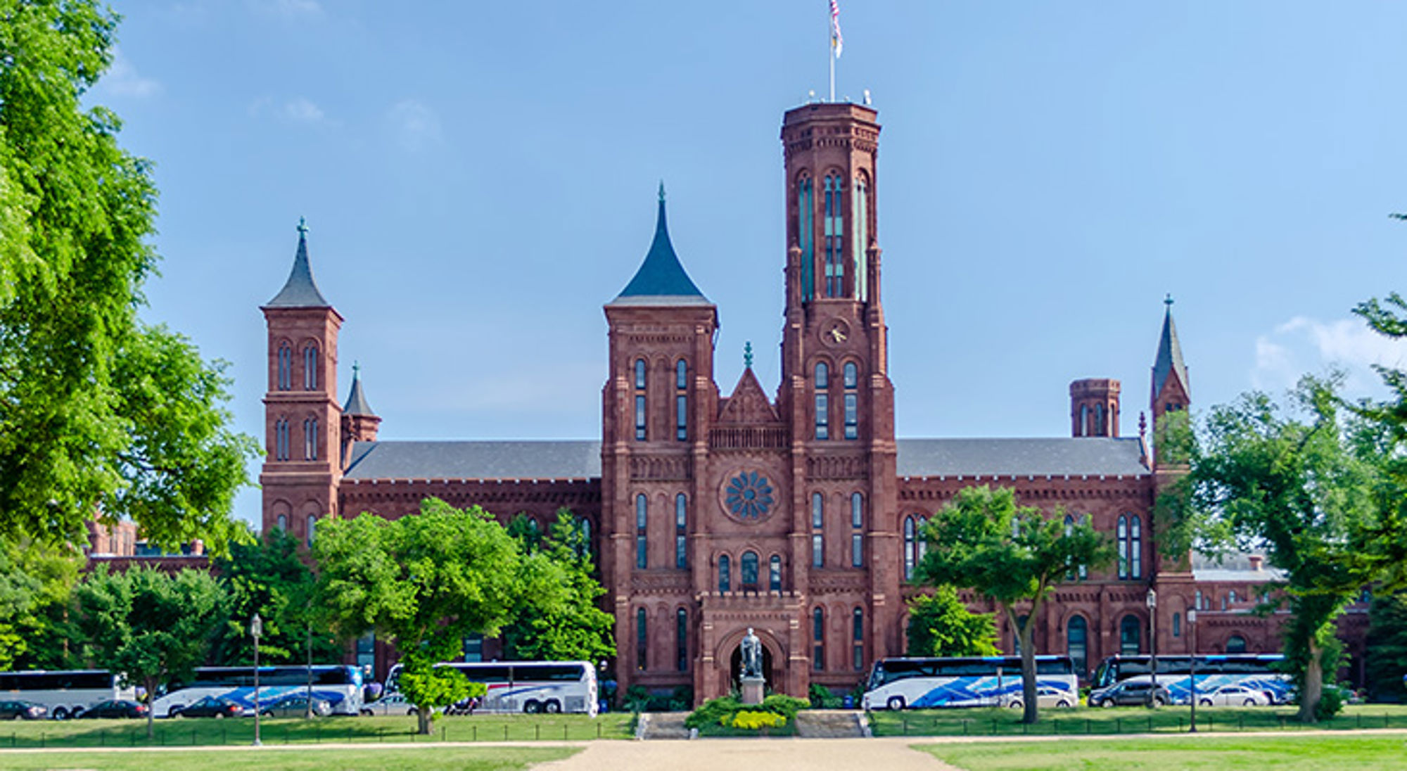 Smithsonian Institution Smithsonian Castle in Washington D.C. met torens en groen park op de voorgrond.