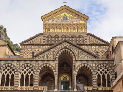Gevel van de kathedraal van Amalfi aan de Amalfikust in Italië, met mozaïeken en bogen.