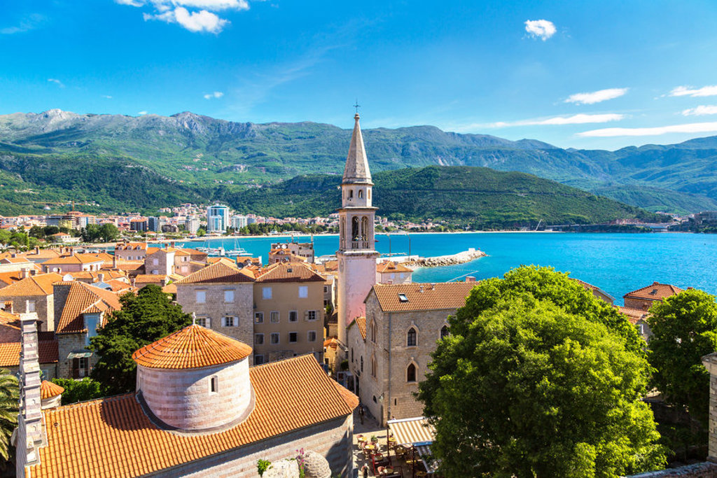 Uitzicht op Budva met kerktoren, rode daken en de Adriatische Zee, tijdens groepsrondreis Balkan.