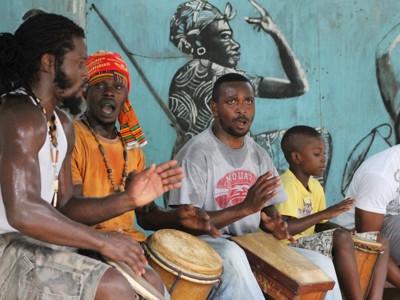 Jamaicaanse muzikanten en een jongen spelen trommels tijdens een straatoptreden op Jamaica.