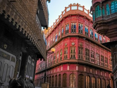 Roze haveli met turquoise ramen in een smalle straat in Jodhpur, Rajasthan.