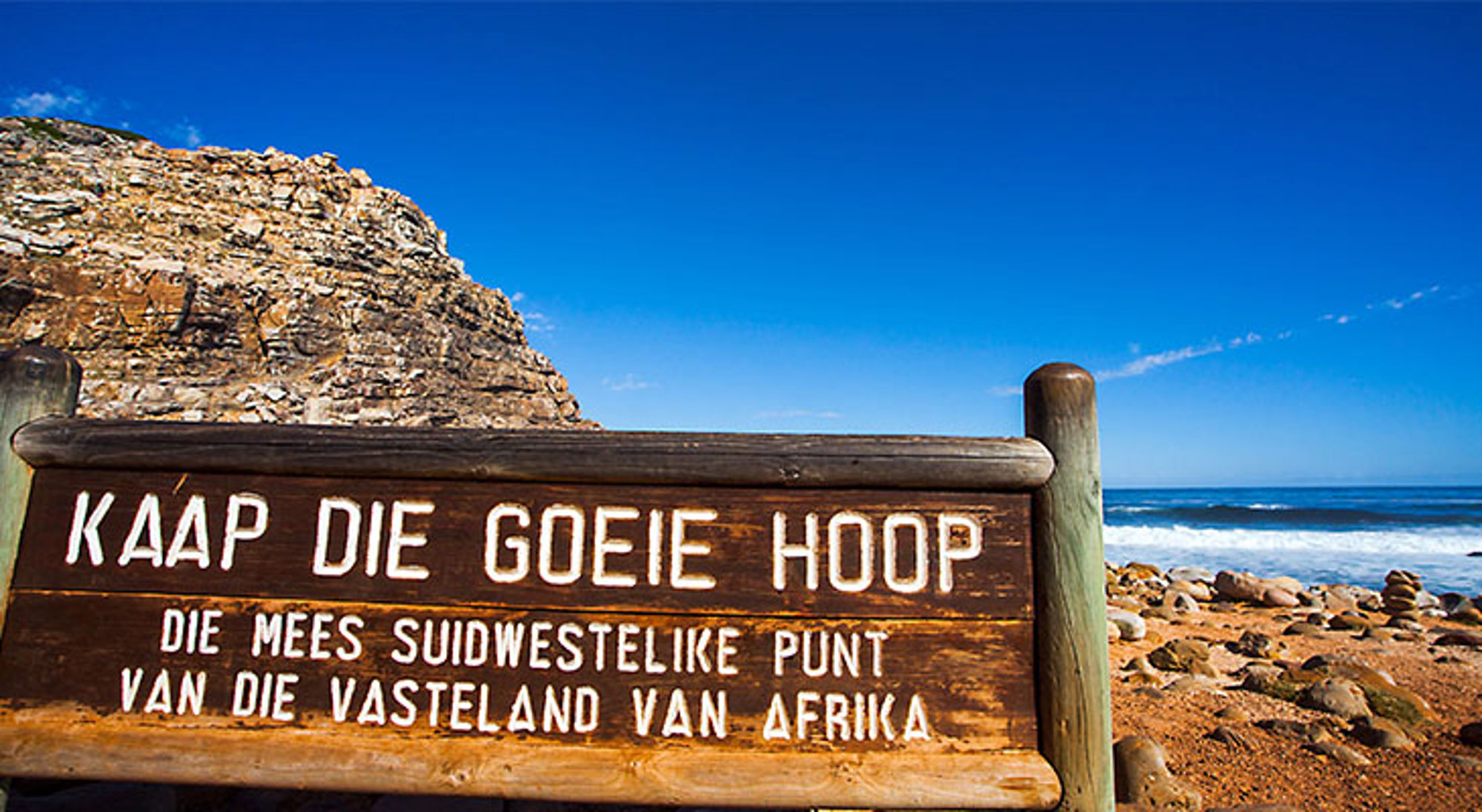 Kaap de Goede Hoop bord Houten bord met “Kaap die Goeie Hoop” bij de rotskust en oceaan in Zuid-Afrika.