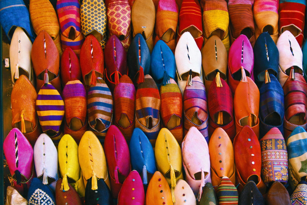 Kleurrijke Marokkaanse leren babouches op een markt, onderdeel van een familiereis Marokko.