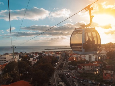 Kabelbaan boven Funchal op Madeira bij zonsondergang, met uitzicht op de stad en de Atlantische Oceaan.