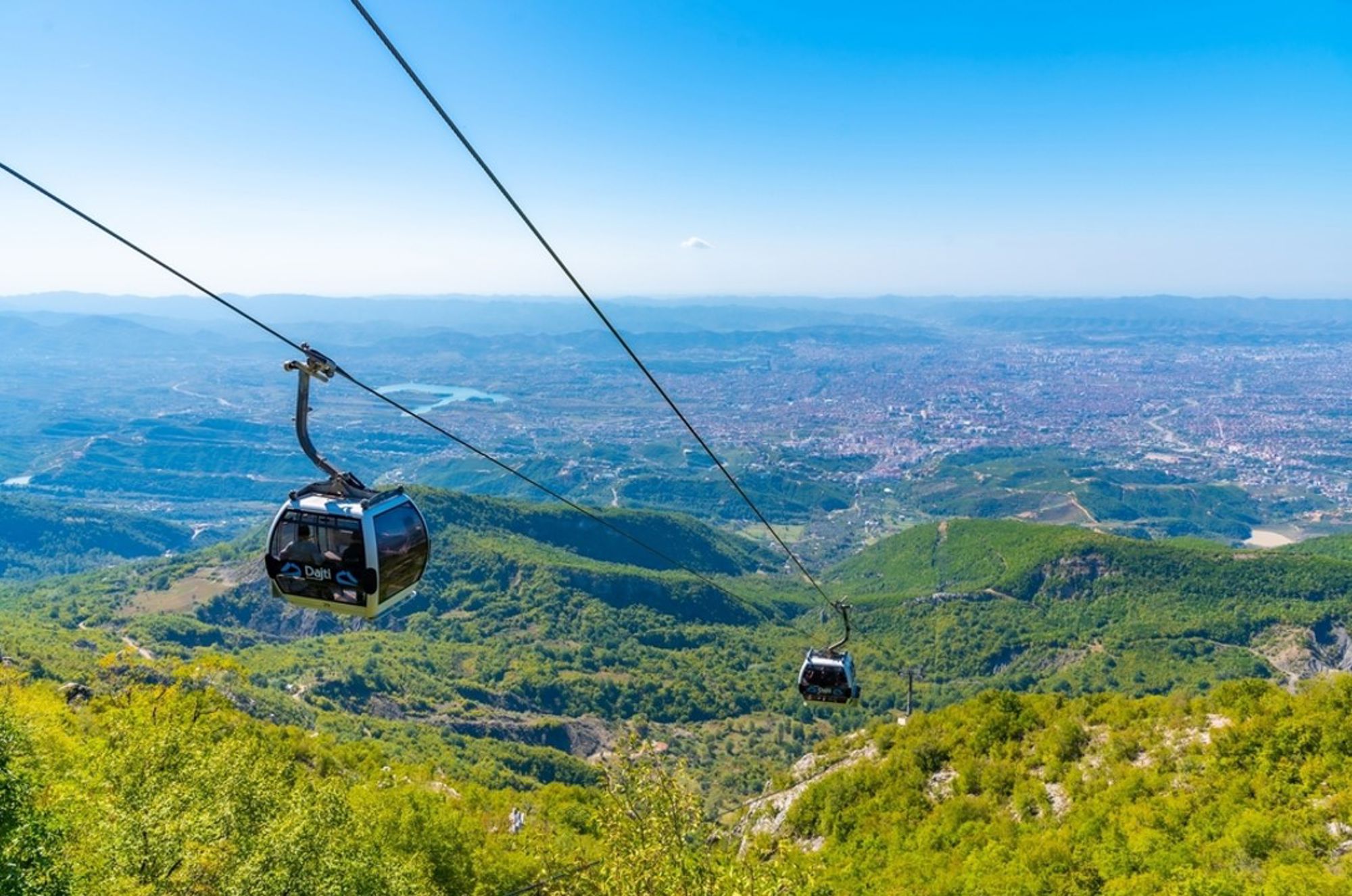 Kabelbaan naar de Dajti-berg met uitzicht over Tirana en de groene heuvels van Albanië.