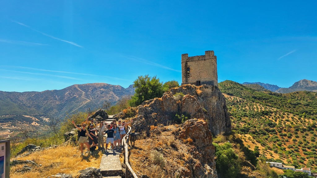 Groep 22-35ers bij een oude wachttoren in het berglandschap van Andalusië, Spanje.