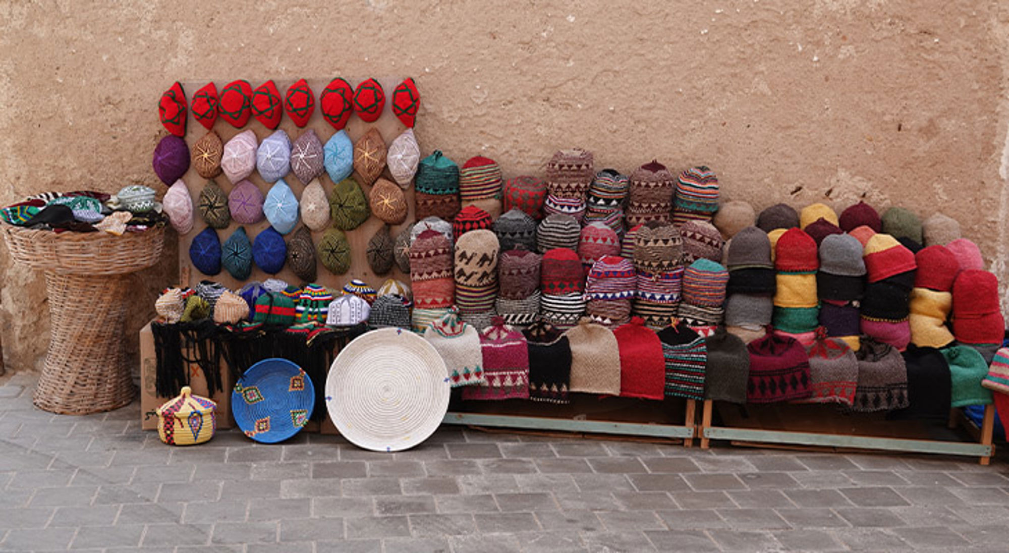 Essaouira Kleurrijke gebreide mutsen en handgemaakte manden uitgestald op een markt.