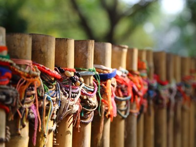 Kleurrijke armbandjes en touwtjes aan bamboepalen langs de route Thailand, Laos & Cambodja.